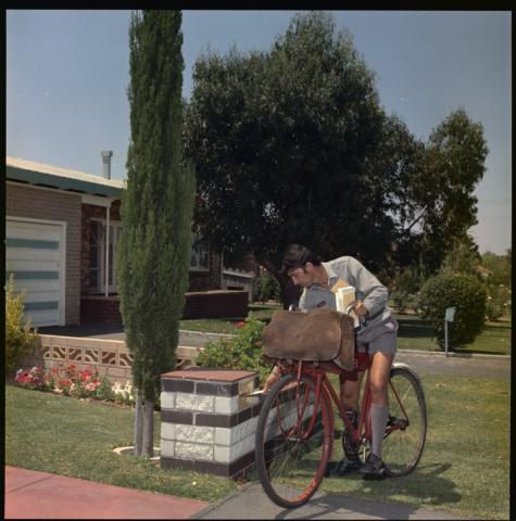 A man delivering mail using a bicycle