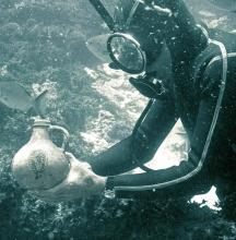 A diver underwater holding an object